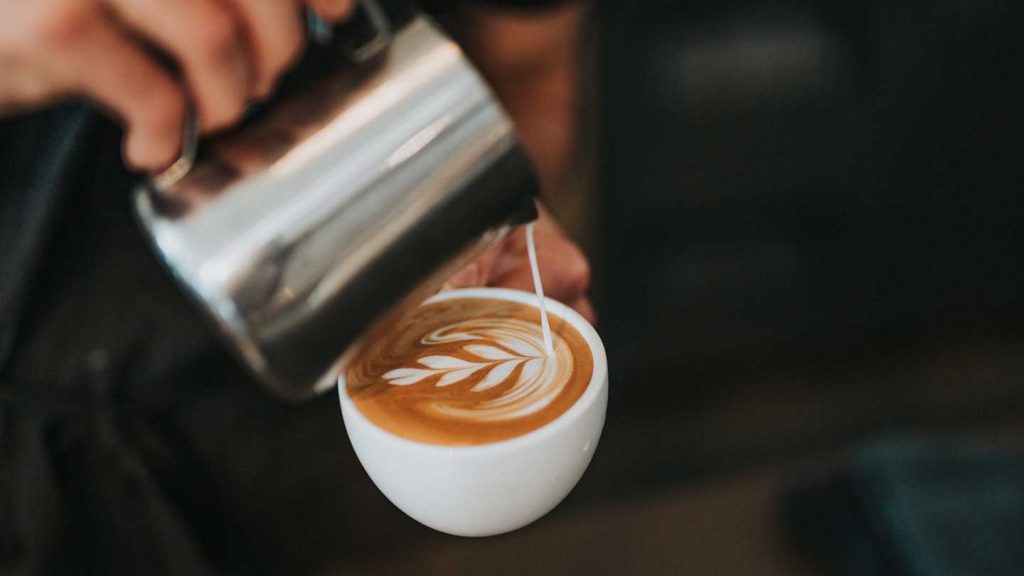 Pouring milk into an expresso