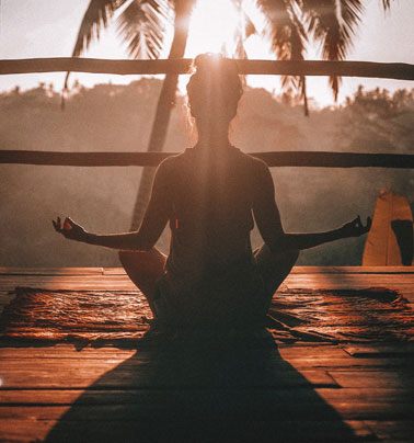 Woman doing yoga at sunrise