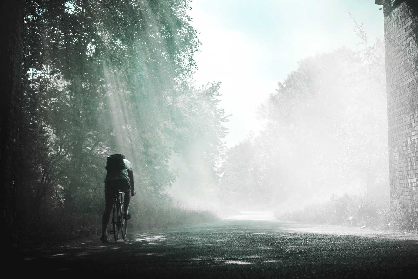 man cycling under bridge